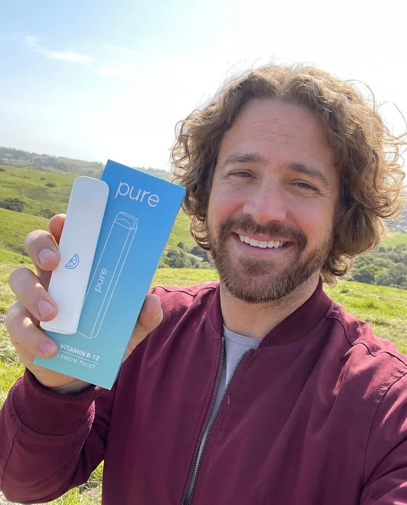 Smiling customer holding his Pure Lemon Twist diffuser and box outdoors